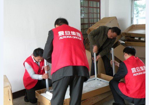 行銷組李家暉總監(右一)、家具上海事業部閘北責任中心楊侃經理(左二)、崇明縣新河鎮民政辦秦衛明主任(右二)一起動手參與組裝辦公桌，大家熱情高漲